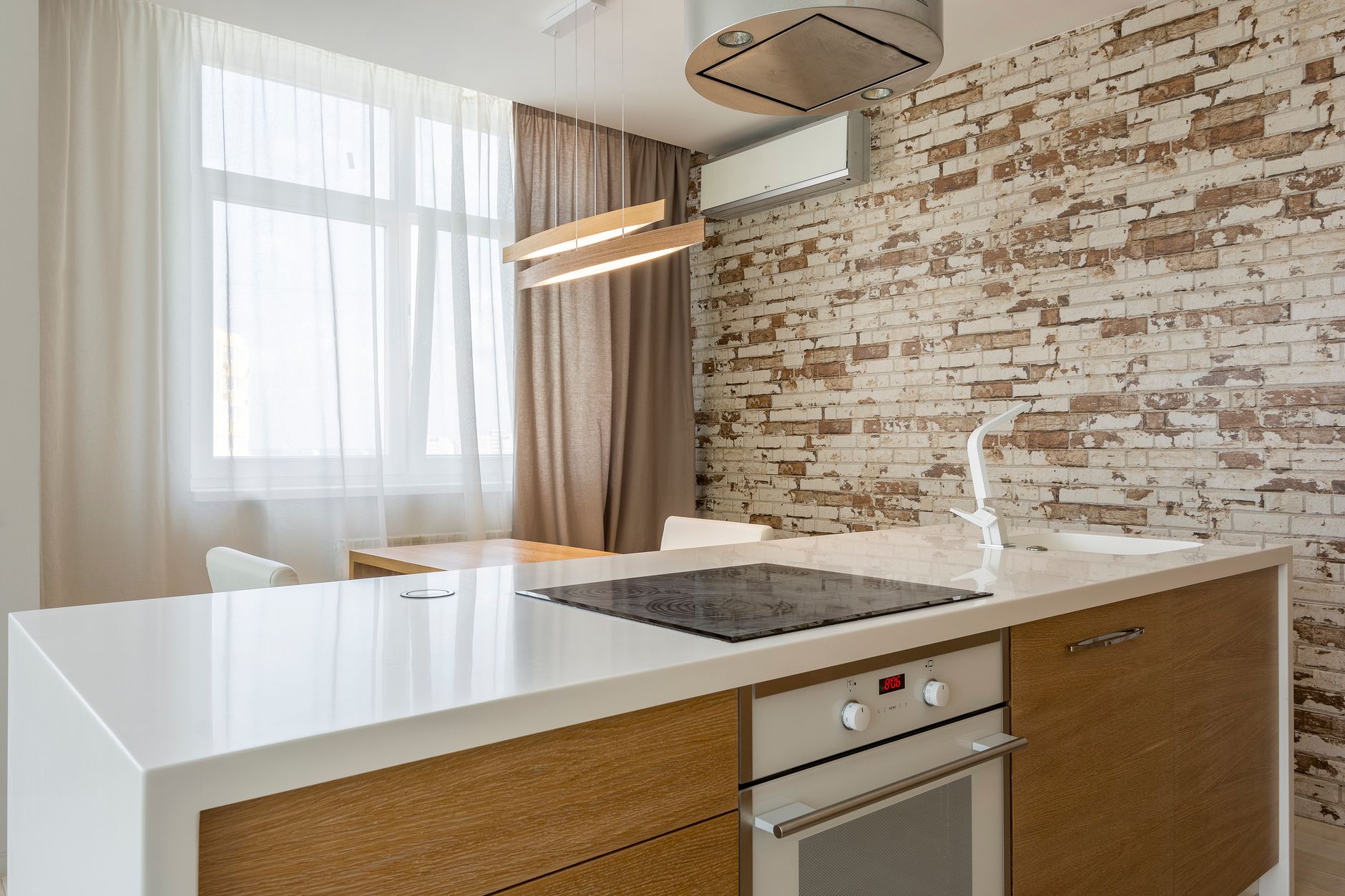 A modern kitchen interior featuring a sleek countertop and brick accent wall for a cozy atmosphere in Riverside, CA